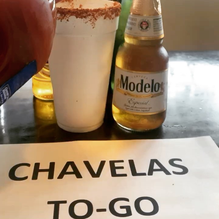 Un vaso escarchado con chile y una cerveza junto a un letrero: "Chavelas To-Go"