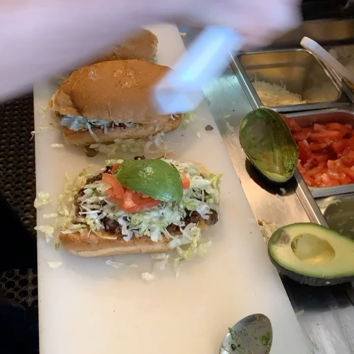 Their torta being built on the line, avocado halves beside it